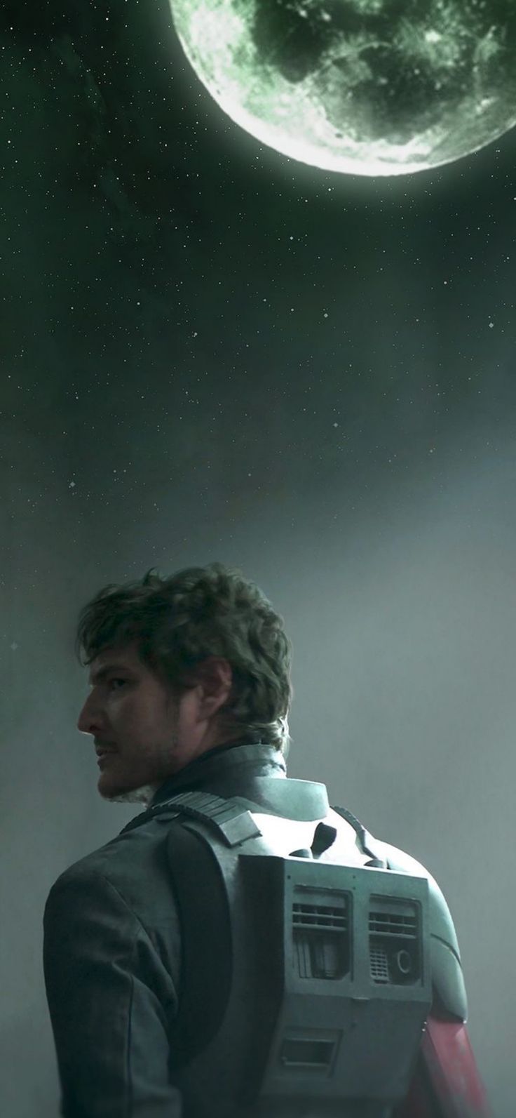 a man standing in front of a green and white planet with stars on the sky