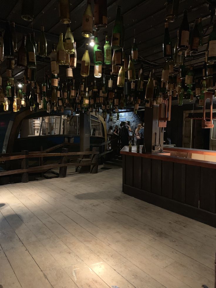 an empty restaurant with lots of bottles hanging from the ceiling