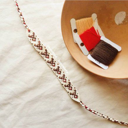 a bowl with a toothbrush in it next to a white and red thread spool