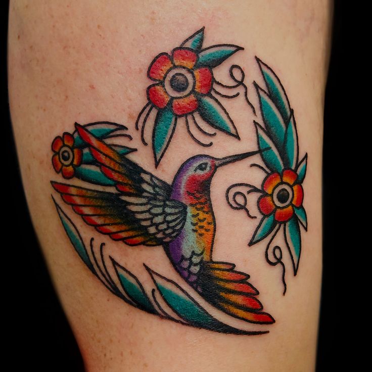 a colorful hummingbird tattoo on the thigh