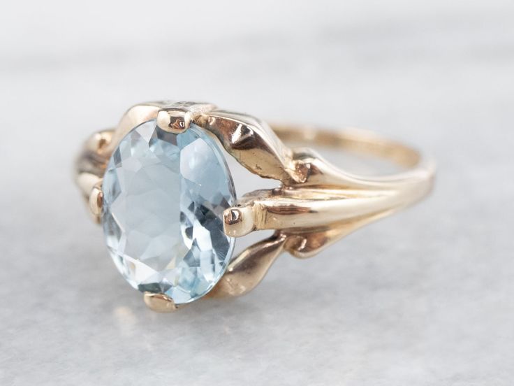 This stunning aquamarine has been set into this Retro era solitaire ring. The cool blue tones contrast beautifully with the warmth of the vintage mounting, while the tapered shoulders draw light into the sparkling gem. This is a lovely piece that is pretty enough to wear alone, yet versatile enough to stack with other rings!Metal: 10K Yellow GoldGem: Aquamarine 1.37 CaratsGem Measurements: 8.5 x 6.9 mm, OvalRing Size: 5.25Marks: "10K" Stamped on the inside band