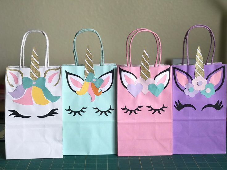 three bags with unicorn faces painted on them