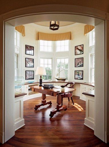 an open door leading to a room with pictures on the wall and a desk in it