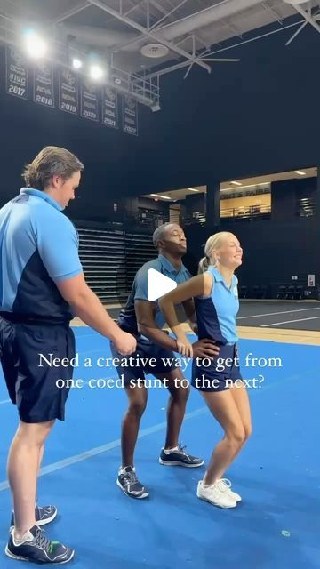 two women in blue shirts and black shorts standing on a tennis court with an instructor