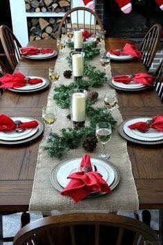 the table is set for christmas dinner with candles and napkins