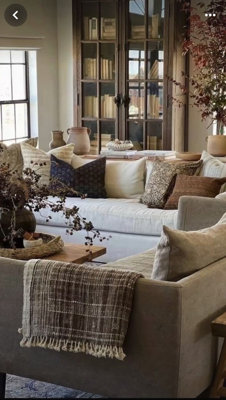 a living room filled with lots of furniture and pillows on top of it's couches