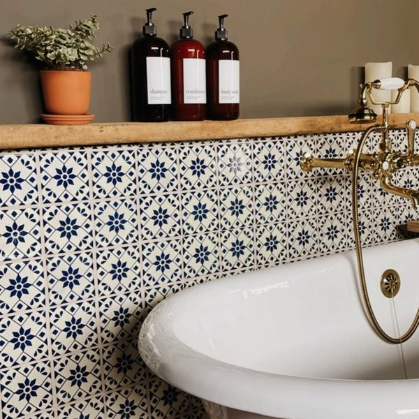 a bath tub sitting next to a shelf filled with bottles