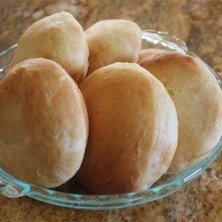 a glass bowl filled with rolls on top of a counter