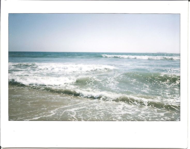 an ocean scene with waves crashing on the beach