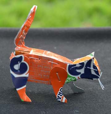 an origami cat made out of orange and blue paper on a black surface