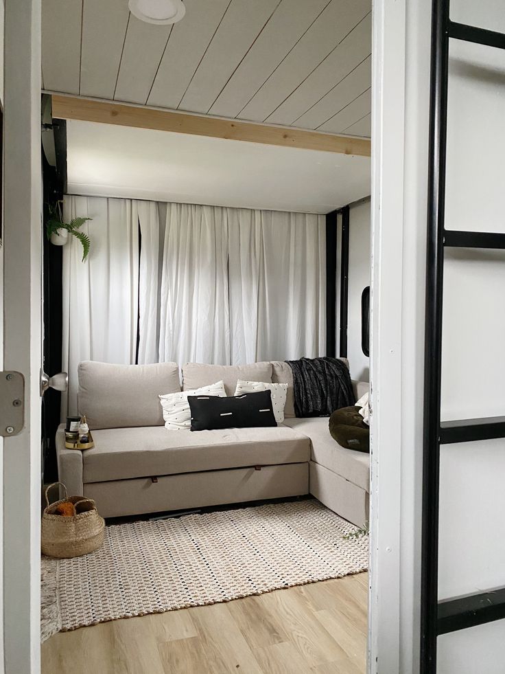 a living room with white walls and wood floors