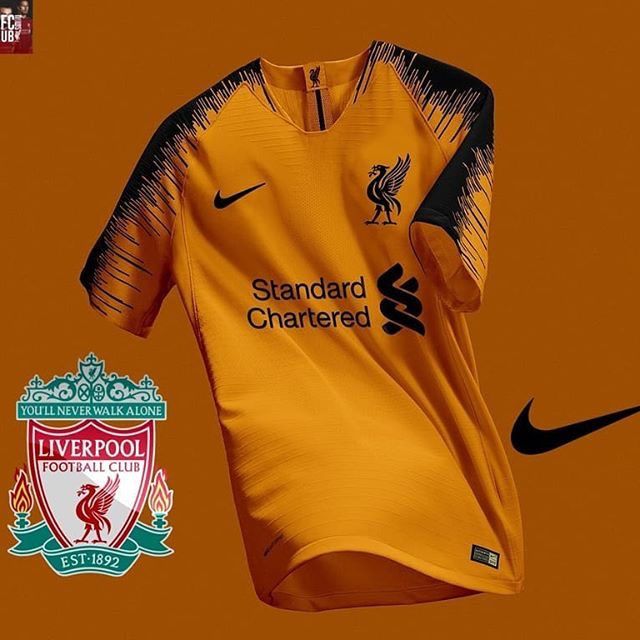 an orange shirt with black writing on it and the liverpool logo in front of it