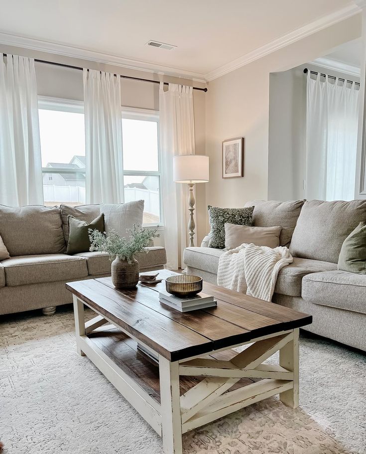 a living room with two couches and a coffee table in front of the window