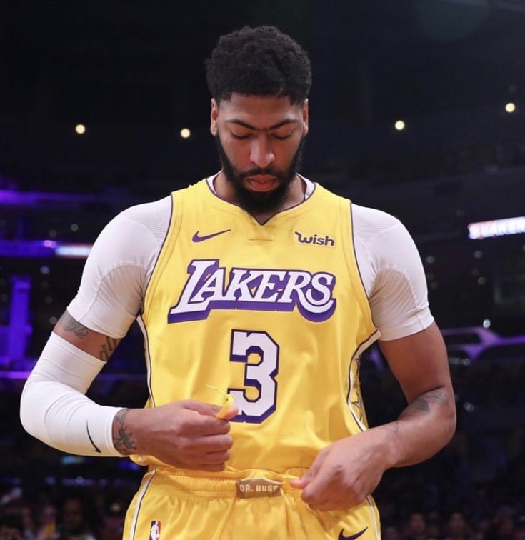 a man in a lakers uniform looking at his cell phone