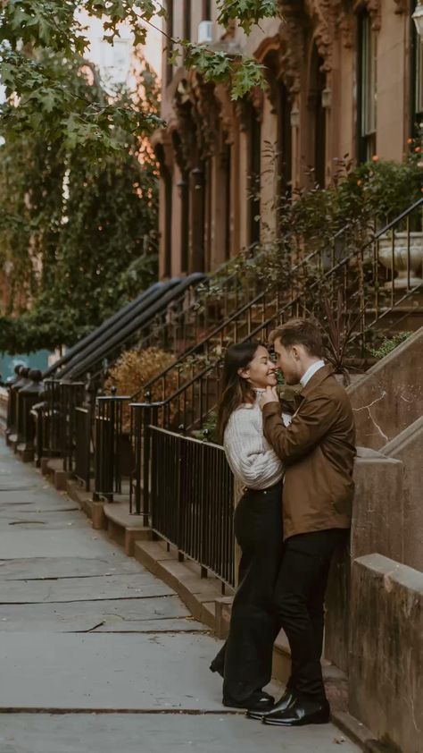 a man and woman standing next to each other in front of a building on a city street