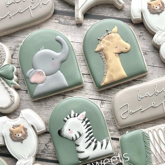 baby shower cookies decorated like animals and giraffes on a wooden table top