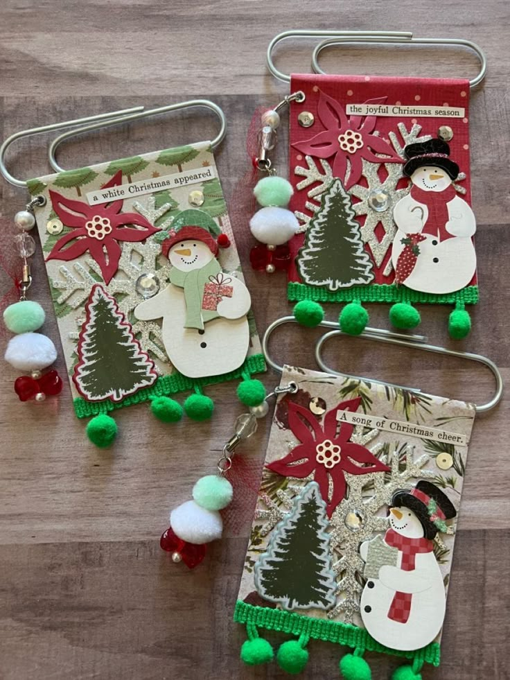 three christmas card holders with pom poms and snowmen on the bottom one