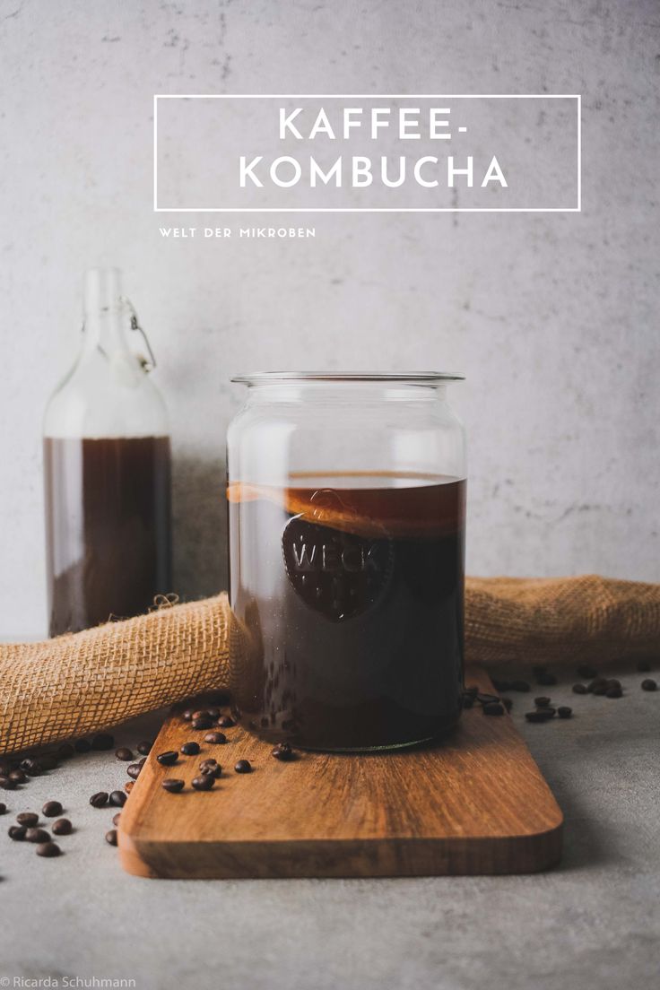 a glass jar filled with coffee sitting on top of a wooden cutting board