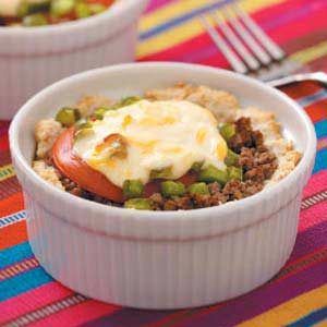 two white bowls filled with food sitting on top of a colorful table cloth next to silverware