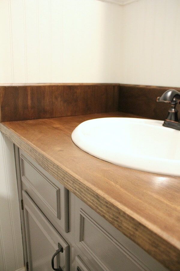 a bathroom sink sitting on top of a wooden counter