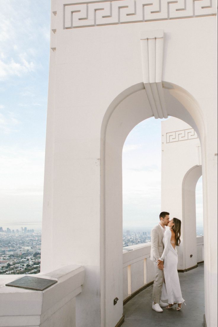 a man and woman standing on top of a building