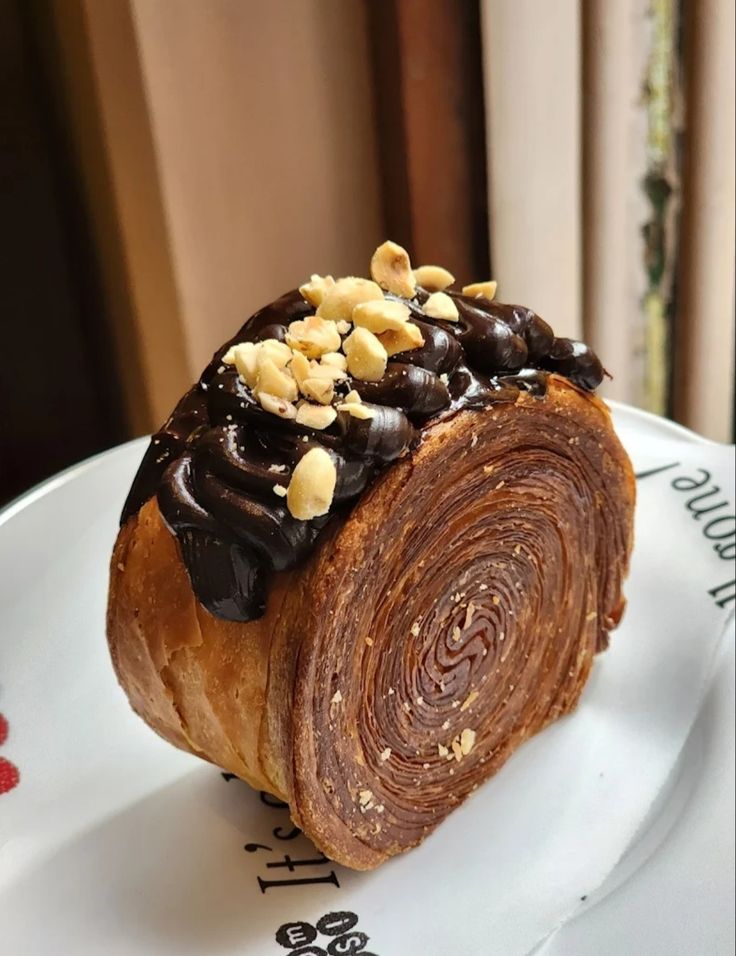 a pastry on a plate with nuts and chocolate