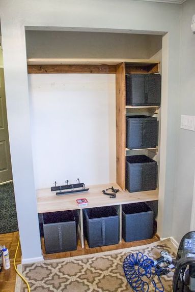 an empty room with several storage bins on the floor and shelves in the wall