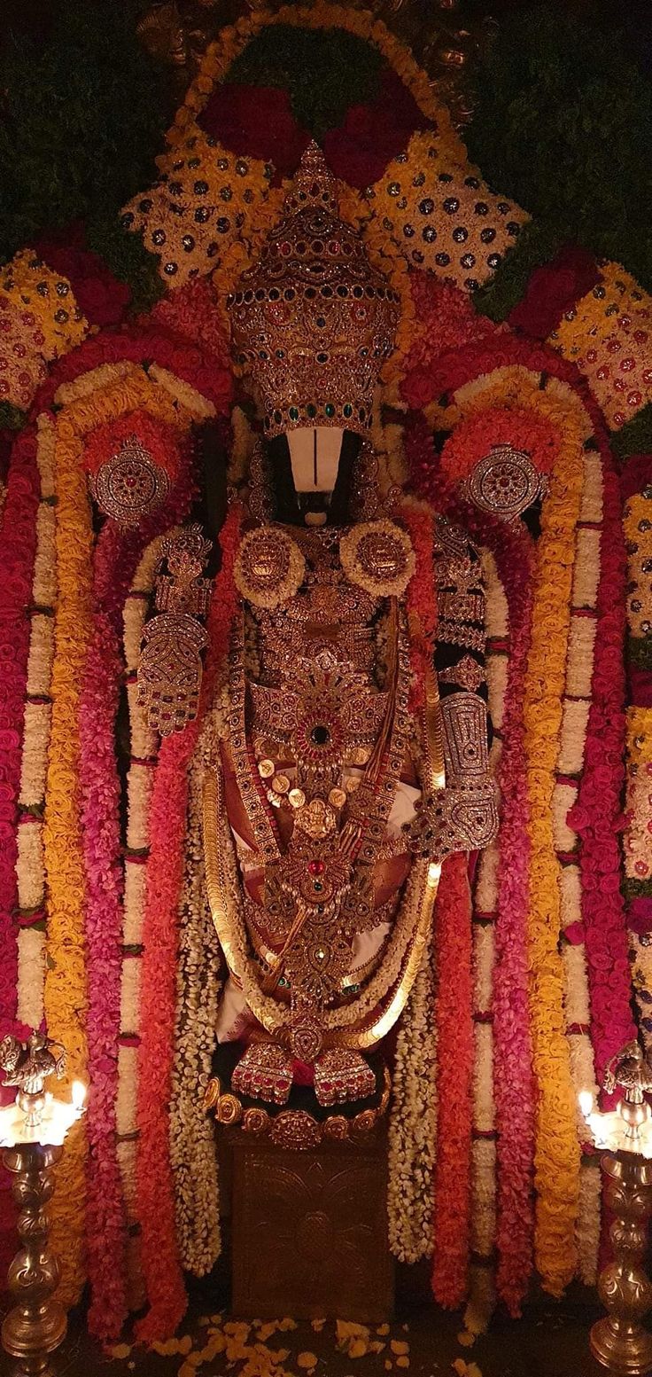 the statue is decorated with flowers and candles