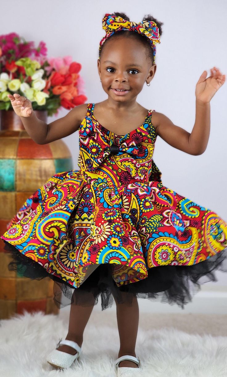 Beautiful Tope Ankara dress is so beautiful and colorful. Your Diva will make a statement wearing this dress. Comes with a big bow at the back and in front. Also comes with a matching hand band Mid knee length. Available for immediate shipping. See shipping options at checkout Red Sleeveless Dress With Bow, Fitted Bow Print Summer Dress, Red Summer Dress With Bow, Multicolor Sleeveless Sundress For Party, Summer Multicolor Dress With Bow, Fitted Multicolor Sundress With Tie Back, Red Dresses With Vibrant Print For Party, Spring Multicolor Dress With Bow, Multicolor Sundress For Party