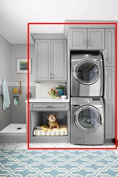 a washer and dryer in a small room with blue rug on the floor