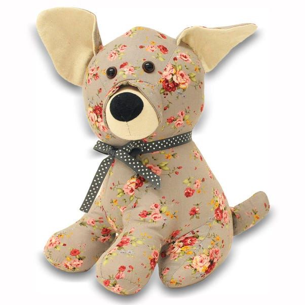 a stuffed dog with flowers on it's head and ears, sitting in front of a white background