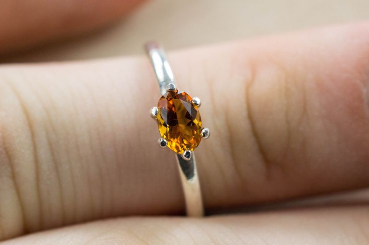 This is an absolutely stunning Citrine from Uruguay set in Sterling Silver. Uruguay Citrine is one of the highest quality Citrine on the market with is high quality orange and gold colors. This beautiful stone has the perfect vivid golden orange color with a fantastic oval cut, amazing luster and clarity, you will surely not be disappointed in this!! Citrine is one of the Birthstones for November! This nicely sized 6.5mm X 4mm Oval Citrine weighs 0.405 carats and will go great with most styles o Classic Orange Topaz Ring For Gift, Classic Orange Topaz Ring Gift, Classic Orange Topaz Ring As Gift, Orange Oval Topaz Jewelry, Oval Orange Topaz Jewelry, Orange Oval Topaz Promise Ring, Oval Orange Topaz Ring For Promise, Oval Orange Topaz Promise Ring, Gift Orange Topaz Gemstone Ring