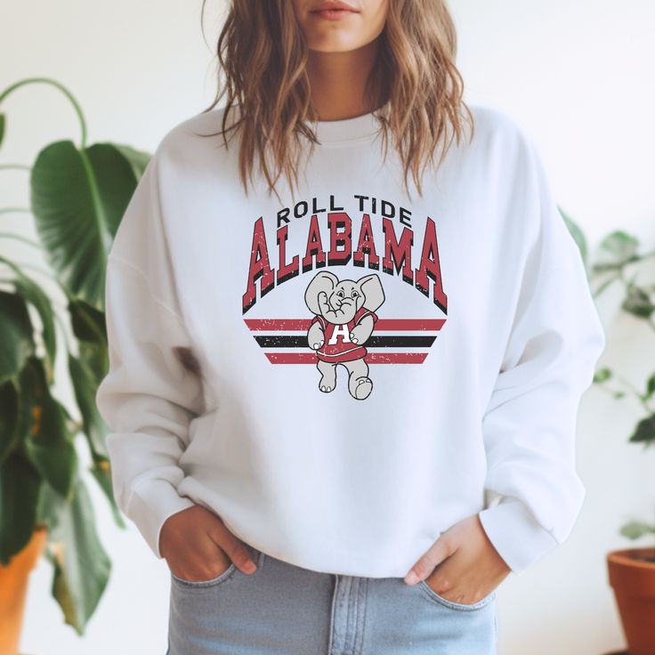 *Also available as a t-shirt. See below.* Show off your support for the Alabama Crimson Tide with our Retro Football Sweatshirt! Stay cozy while cheering on your team in this football sweater. Perfect for game day or any day. Roll Tide! White Sports Fan Sweatshirt For Fall, White Sports Fan Tops, White Winter Sports Fan Tops, Varsity Sweatshirt With Team Logo For Game Day, Collegiate Sweatshirt With Mascot For College, Collegiate Mascot Sweatshirt For College, Varsity White Sweatshirt For Football Season, Team-colored Sweatshirt With Mascot For Fans, Team-colored Fan Apparel Sweatshirt For Game Day