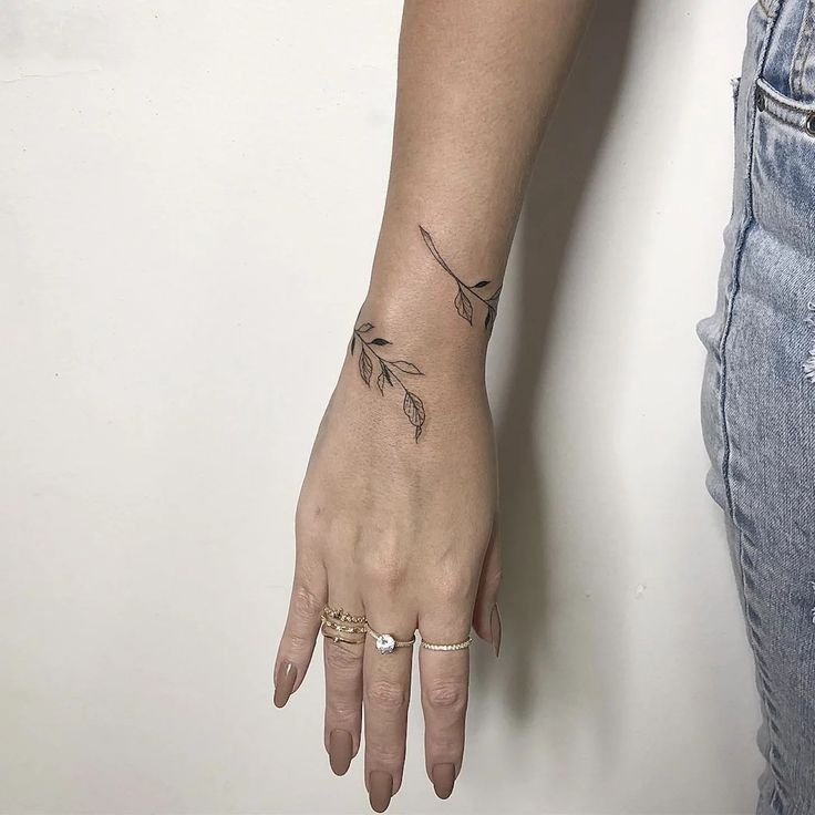 a woman's hand with a small tattoo on it