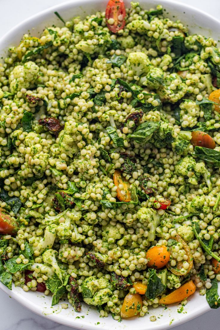 a white bowl filled with broccoli and other vegetables