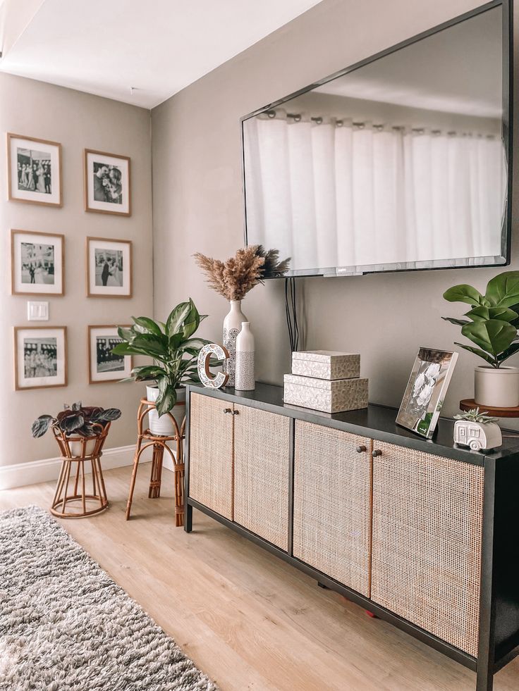 a living room with a large mirror on the wall and some plants in vases