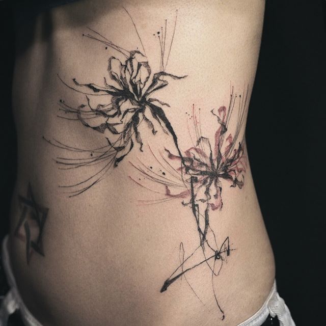 a woman's stomach with an artistic tattoo design on her lower back and side