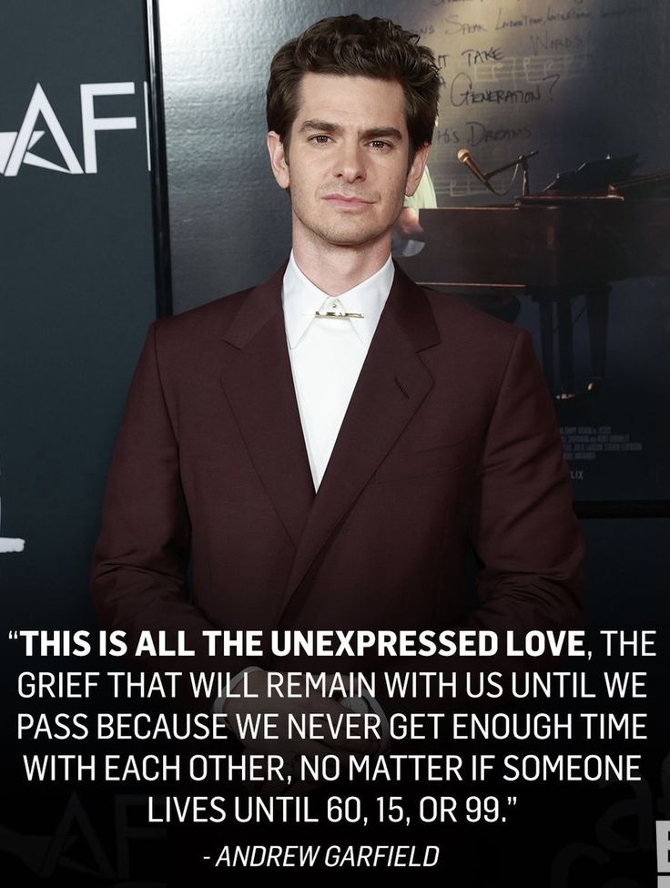 a man in a suit and tie standing next to a wall with a quote on it