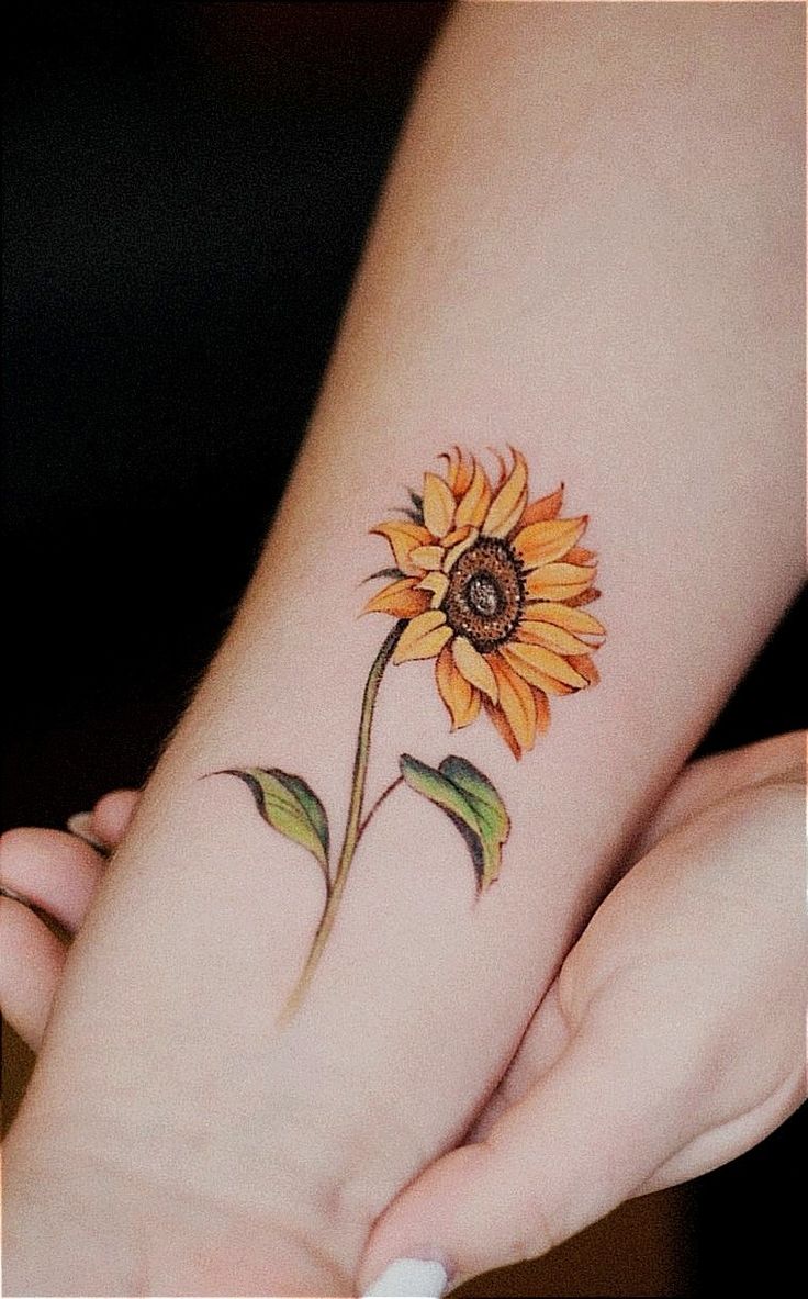 a small sunflower tattoo on the wrist