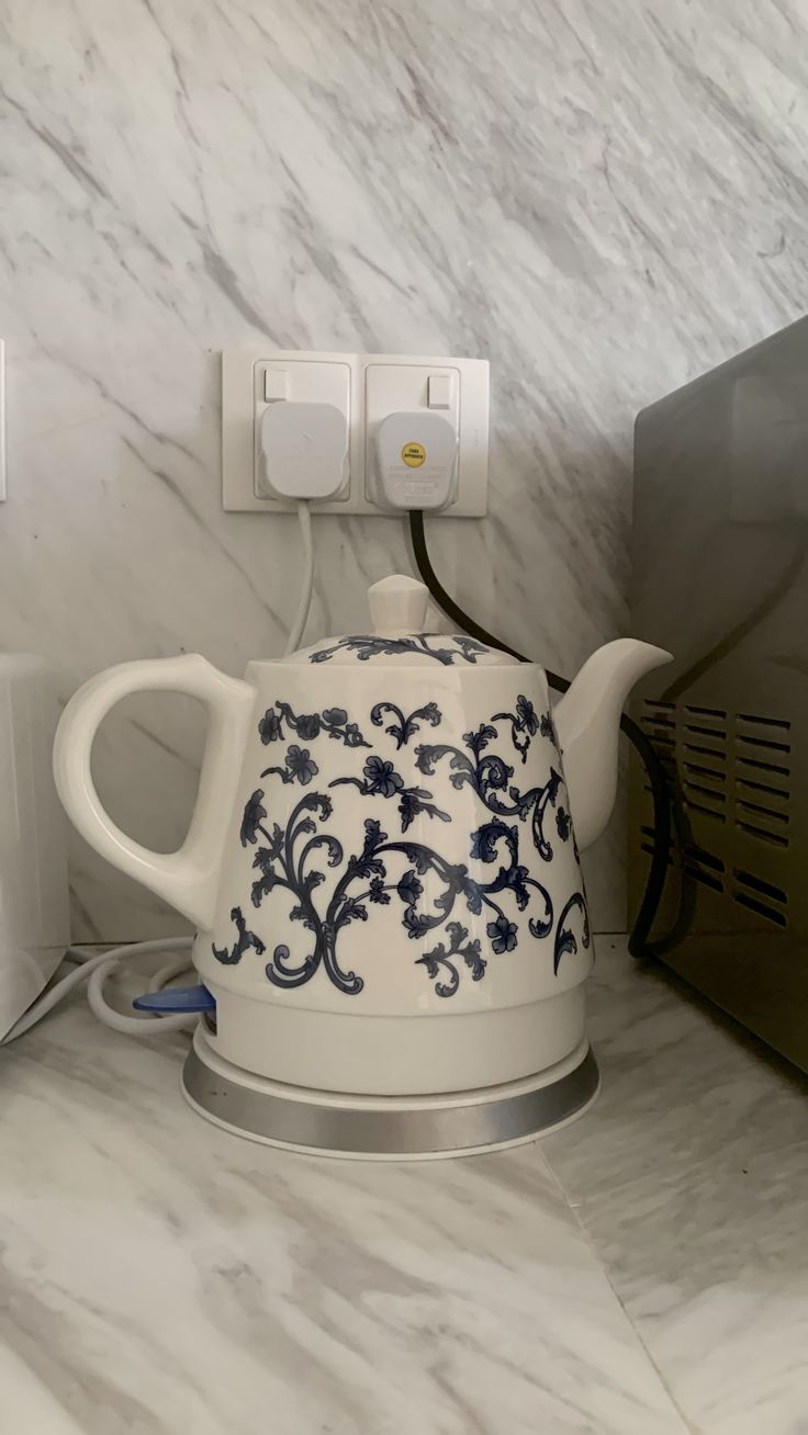 an electric tea kettle sitting on top of a counter