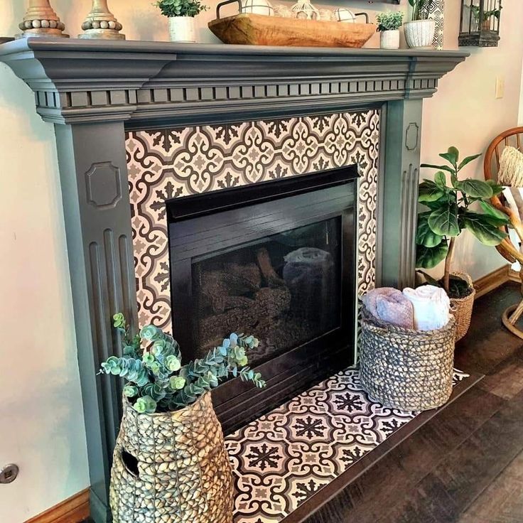 a living room with a fire place and potted plants on top of the fireplace