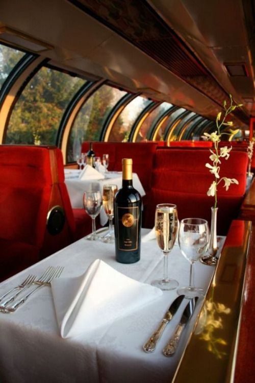 a table with wine glasses and silverware on it next to a bottle of wine