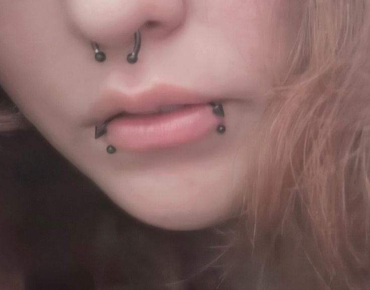 a woman with piercings on her nose looking at the camera