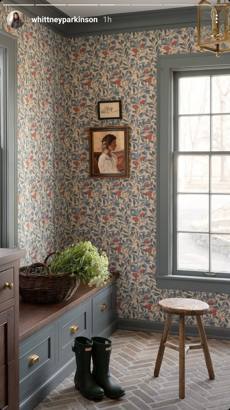 a room with wallpaper and wooden furniture in the corner, along with a window