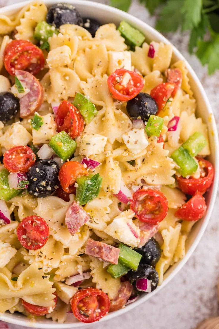 a white bowl filled with pasta salad on top of a table