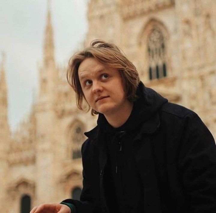 a man standing in front of a tall building