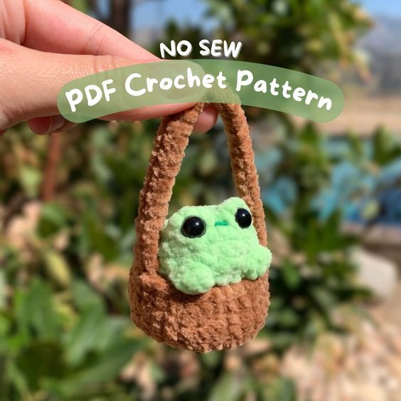 a small crocheted bag with a green frog in it's pocket and the words no sew