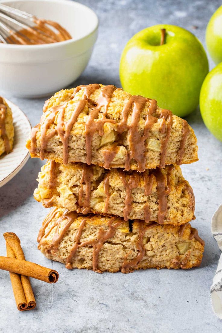 stack of apple scones with caramel glaze on top and cinnamon apples in the background