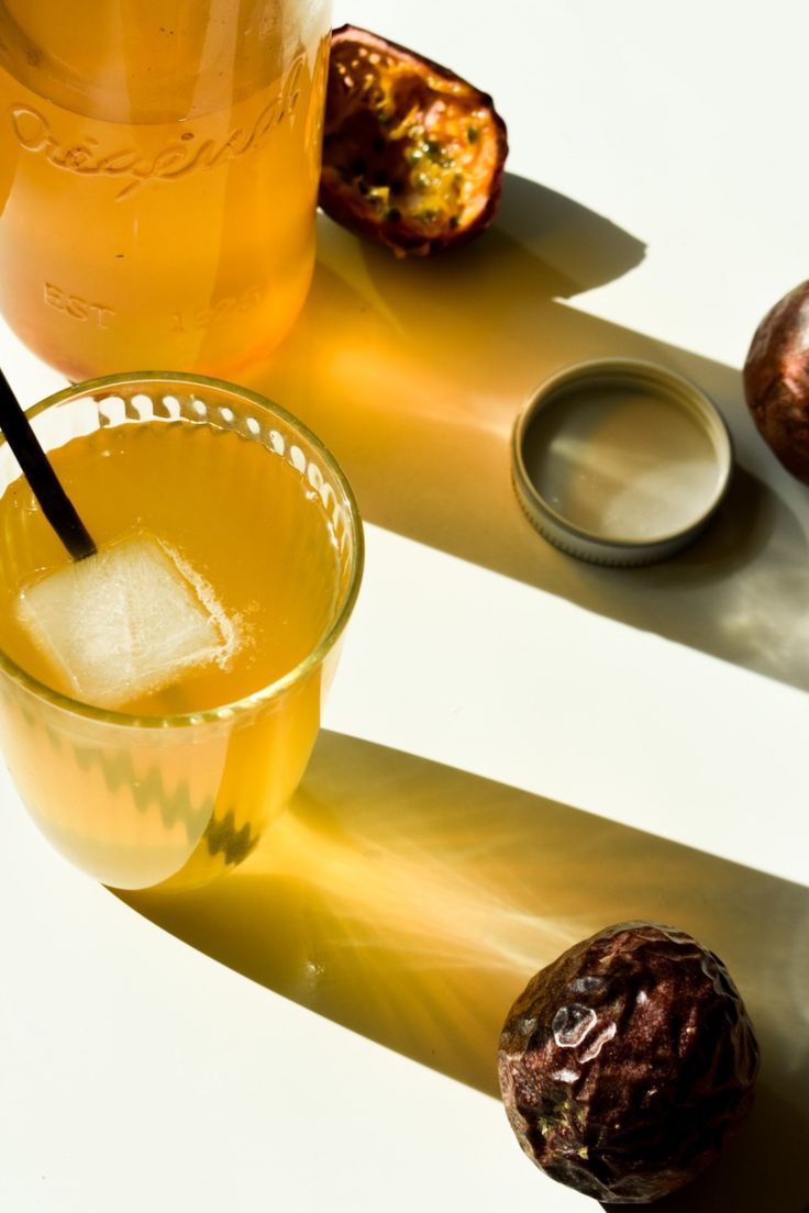 a glass filled with liquid next to some fruit