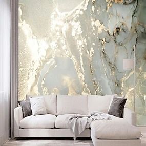 a white couch sitting in front of a wall with marble design on it's walls